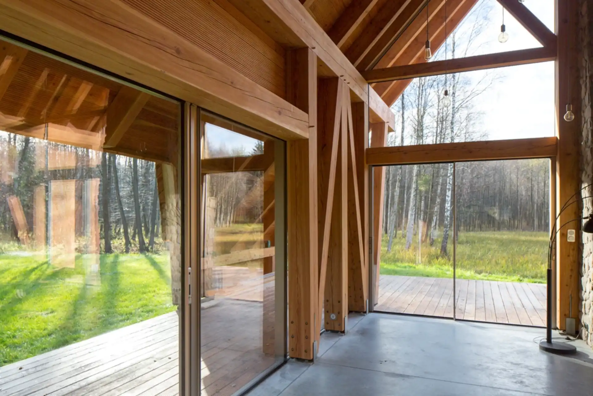 A-frame cottage with glass bi-fold door panels and timber structure at twilight